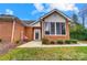 Charming brick home featuring a cozy sunroom with large windows and beautifully landscaped front yard at 8405 Olde Troon Dr # 4A, Charlotte, NC 28277