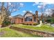 Beautiful brick home with an attached sunroom, complemented by mature trees and well-maintained landscaping at 8405 Olde Troon Dr # 4A, Charlotte, NC 28277