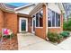 Inviting front porch with a stylish door, surrounded by lush greenery and classic brick architecture at 8405 Olde Troon Dr # 4A, Charlotte, NC 28277