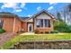 Charming brick home featuring a cozy sunroom with large windows and beautifully landscaped front yard at 8405 Olde Troon Dr # 4A, Charlotte, NC 28277