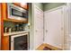 Kitchen area featuring built-in microwave and wine cooler next to a door leading to an additional room at 8405 Olde Troon Dr # 4A, Charlotte, NC 28277