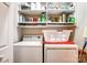 Organized laundry room with ample shelving, washer, dryer, and storage space for supplies at 8405 Olde Troon Dr # 4A, Charlotte, NC 28277
