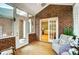 Bright sunroom featuring brick walls, white wicker furniture, and abundant natural light at 8405 Olde Troon Dr # 4A, Charlotte, NC 28277