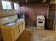 Unfinished basement with sink, stove, and brick walls at 8725 Bringle Ferry Rd, Salisbury, NC 28146