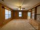 Living room featuring wood paneling, large windows, and built-in shelving at 8725 Bringle Ferry Rd, Salisbury, NC 28146