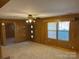 Spacious living room with wood paneling, ceiling fan, and built-in shelving at 8725 Bringle Ferry Rd, Salisbury, NC 28146