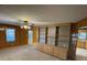 Living room with wood paneling, built-in shelving and access to kitchen at 8725 Bringle Ferry Rd, Salisbury, NC 28146