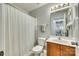 Well-lit bathroom featuring a shower with a striped curtain, toilet, and vanity with wood cabinets and a mirror at 10238 Highland Creek Cir, Fort Mill, SC 29707