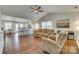 Open living room featuring hardwood floors, a ceiling fan, a comfortable sofa and an open layout to the kitchen at 10238 Highland Creek Cir, Fort Mill, SC 29707