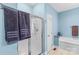 This bathroom features a glass-enclosed shower, soaking tub, tile floor and light blue walls at 103 Granville Ln, Salisbury, NC 28146