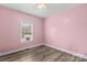 The pink bedroom has wood-look floors, a window with blinds, and neutral trim at 103 Granville Ln, Salisbury, NC 28146