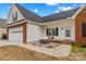 Inviting front entrance featuring a modern fire pit and stone landscaping, and close proximity to the garage at 103 Granville Ln, Salisbury, NC 28146