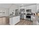 Bright kitchen features stainless steel appliances, granite countertops, white cabinets, and wood-look flooring at 103 Granville Ln, Salisbury, NC 28146