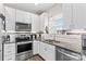 Bright kitchen with white cabinets, stainless steel appliances, and a modern sink beneath a large sunny window at 103 Granville Ln, Salisbury, NC 28146