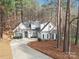 Charming home with stone accents, manicured landscaping, and a long driveway surrounded by mature trees at 117 Cove Pointe, Mount Holly, NC 28120