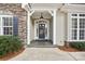 Welcoming front porch with stone accents, and decorative wreath on the front door at 117 Cove Pointe, Mount Holly, NC 28120