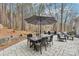 Outdoor patio with dining table and umbrella, surrounded by wooded landscape, ideal for entertaining at 117 Cove Pointe, Mount Holly, NC 28120