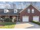 Brick front exterior of charming townhome with 2-car garage and landscaped yard at 121 Quality Dr, Mount Holly, NC 28120