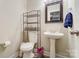 Clean bathroom with pedestal sink and storage shelving at 1605 Merry Oaks Rd # E, Charlotte, NC 28205