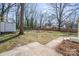 Large backyard surrounded by mature trees and an expansive lawn, perfect for outdoor activities at 2100 Knickerbocker Dr, Charlotte, NC 28212