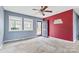 Living room with grey and red walls, carpeting, and ceiling fan at 2209 Donnabrook Ln, Gastonia, NC 28052