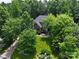 Aerial view of a brick home nestled amongst mature trees and lush landscaping at 252 Bay Shore Loop, Mooresville, NC 28117