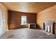 Simple bedroom with hardwood floors, wood walls, and a fireplace at 2948 W Main St, Claremont, NC 28610