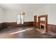 Living room with hardwood floors, wood walls, and a brick fireplace at 2948 W Main St, Claremont, NC 28610