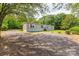 Side view of a single-story home with gravel driveway, manicured lawn, and classic siding at 3035 Agean Ln, York, SC 29745