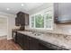 Well-lit kitchen boasts dark cabinetry, granite countertops, and stainless steel appliances at 3035 Agean Ln, York, SC 29745