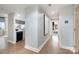 Hallway with hardwood floors leading to a modern kitchen and cozy living area with artwork on the wall at 315 Arlington Ave # 604, Charlotte, NC 28203