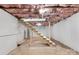 Unfinished basement with exposed ceiling and wooden stairs at 315 W 2Nd St, Cherryville, NC 28021