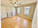 A sunny bedroom featuring wood-look flooring, two windows, built-in shelving, ceiling fan and neutral paint at 3153 Wimbledon Ln, Rock Hill, SC 29732