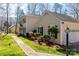 Side view of a tan two-story home with an attached garage, complemented by lush landscaping at 3153 Wimbledon Ln, Rock Hill, SC 29732