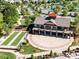 View of the community clubhouse with a bocce ball court, circular driveway and surrounding trees, as well as community amenities at 3207 Oliver Stanley Trl, Lancaster, SC 29720