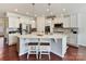 Modern white kitchen with stainless steel appliances and a spacious quartz island with seating at 3207 Oliver Stanley Trl, Lancaster, SC 29720