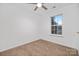 Bright bedroom features neutral carpet, ceiling fan and natural light from window overlooking mature landscaping at 4321 Bobterry Ct, Charlotte, NC 28216