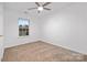 Bright bedroom features neutral carpet, ceiling fan and natural light from window overlooking mature landscaping at 4321 Bobterry Ct, Charlotte, NC 28216