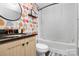 Charming bathroom featuring patterned wallpaper, a vanity with black countertop, and a shower with a curtain at 4923 Park Rd # D, Charlotte, NC 28209