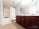 Bathroom with a tub shower combo, double vanity, and wood cabinets at 4968 Sunburst Ln, Charlotte, NC 28213