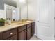 Modern bathroom with dark brown vanity, granite countertop, and a mirror at 501 Alucio Ct, Matthews, NC 28104