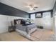 Serene bedroom with dark blue walls, white wainscoting, and ceiling fan at 501 Alucio Ct, Matthews, NC 28104