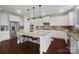 Modern kitchen with white cabinets, granite countertops, and a large island at 501 Alucio Ct, Matthews, NC 28104