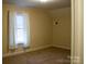 Simple bedroom with neutral walls, carpet, and a window at 518 Oak St, Troy, NC 27371