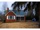 Brick ranch house with a screened porch and mature trees in the yard at 518 Oak St, Troy, NC 27371