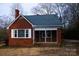 Front view of a red brick ranch house with a screened porch at 518 Oak St, Troy, NC 27371