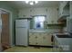 White kitchen cabinets, appliances, and a view into another room at 518 Oak St, Troy, NC 27371