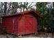 Red wooden storage shed in backyard with a lacrosse stick at 518 Oak St, Troy, NC 27371