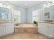 Elegant bathroom with a large soaking tub, double vanity, and lots of natural light at 6819 Conservatory Ln, Charlotte, NC 28210