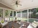 Relaxing screened-in porch with brick flooring, ceiling fan, and outdoor seating for comfortable outdoor enjoyment at 6819 Conservatory Ln, Charlotte, NC 28210